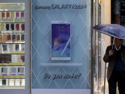 Un hombre junto a una tienda con un anuncio del Samsung Galaxy