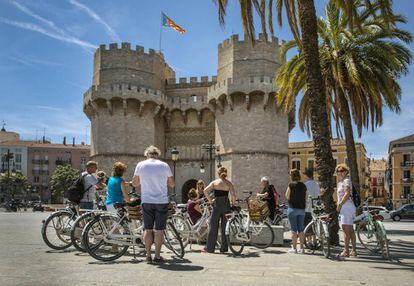 Un grupo de ciclistas en Valencia, frente a las Torres de Serranos. 