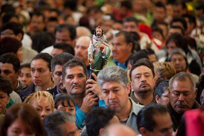 Un devoto de San Judas Tadeo muestra una figura del santo, adorado en México DF por su supuesta capacidad de obrar milagros.
