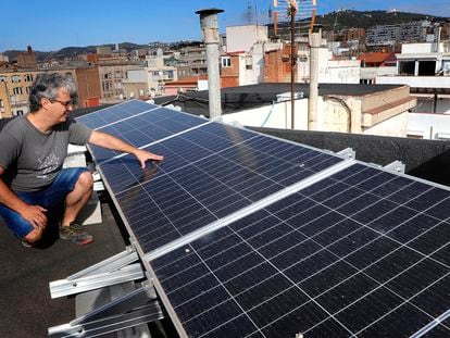 Eduard Moreno, ante los paneles fotovoltaicos que ha instalado en la cubierta del edificio donde vive, en el barrio de Gràcia de Barcelona.