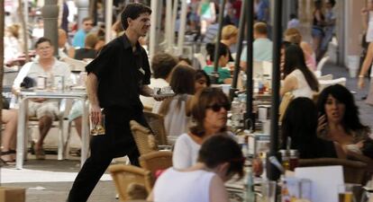 Un camarero trabaja en una terraza en Valencia.