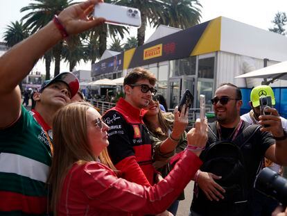 Algunos de los aficionados con entradas VIP se toman una selfie con Charles Leclerc, piloto de Ferrari.