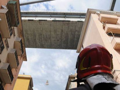 Un bombero observa los edificios evacuados bajo los restos del puente Morandi, en Génova. 