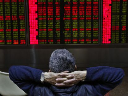 Un inversor chino observa una pantalla que muestra la evolución de los mercados financieros.