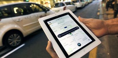 Un usuario de Uber consulta la aplicación en Valencia ante una parada de taxis.