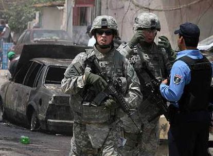Dos soldados estadounidenses y un policía iraquí, tras un atentado ayer en Bagdad.