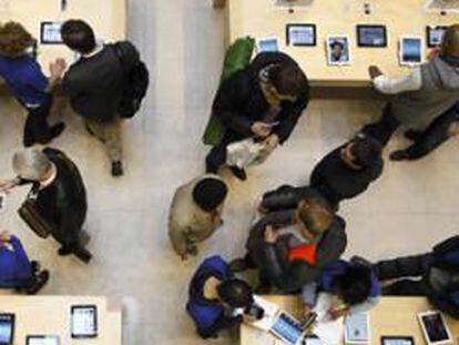 Clientes buscan en las mesas en las que se muestran el Apple IPAD 4G listo para Tablet PC en una de sus tiendas en París, 16 de marzo 2012.