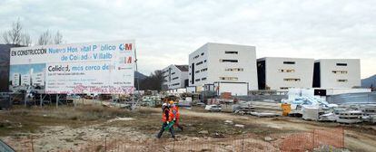 Unos trabajadores caminan por las obras del futuro hospital de Collado Villalba.