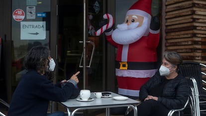 Dos personas conversan con la mascarilla puesta mientras se toman algo en la terraza de un bar, este miércoles en Ourense.