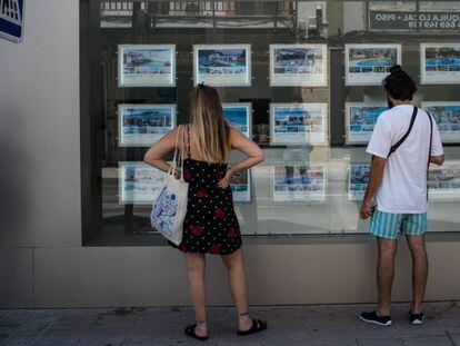 Dos personas observan el escaparate de una inmobiliaria en Palma, el pasado 1 de julio.