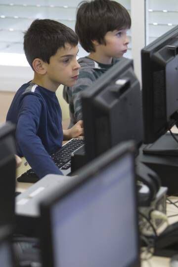 Alumnes de l’escola Reina Violant fent informàtica.