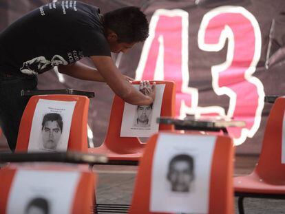 Un alumno de Ayotzinapa pone fotos de los 43.