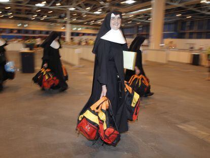 Un grupo de monjas recoge las mochilas que reparten los voluntarios.