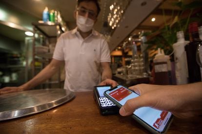 David Fernández, dueño del restaurante Paixariños de Madrid, cobra con datáfono a un cliente.