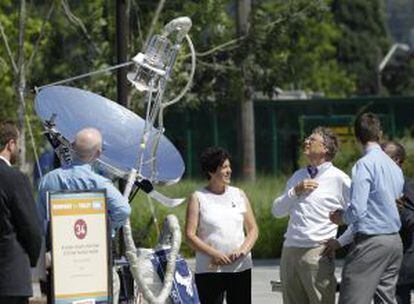 Bill Gates, con jersey blanco, ante un aparato que usa energía solar para transformar los residuos de un retrete.