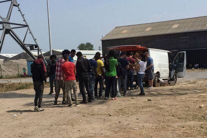 Migrantes en Calais hacen cola para recibir alimentos de una ONG 