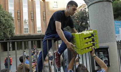 Un hombre ayuda a cargar cajas dentro del colegio de primaria Collaso i Gil, una de los colegios electorales designados para el referéndum.