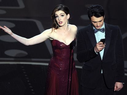 Anne Hathaway mirando al público y James Franco mirando al móvil mientras presentaban la gala de los Premios Oscar del año 2011, una de las que peores críticas ha recibido en los últimos años.