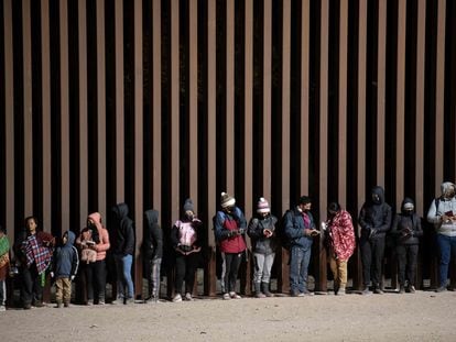 Migrantes en búsqueda de asilo hacen fila para ser procesados por agentes de la Patrulla Fronteriza estadounidense, el pasado 26 de diciembre en la frontera entre Arizona y Sonora.