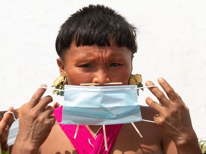 Una indígena yanomami con mascarilla, el 30 de junio en Alto Alegre, en el Estado de Roraima. Según la Articulación de los Pueblos Indígenas de Brasil, 145 pueblos se han visto afectados por la covid-19: más de 18.000 indígenas se han contagiado y 571 han muerto.