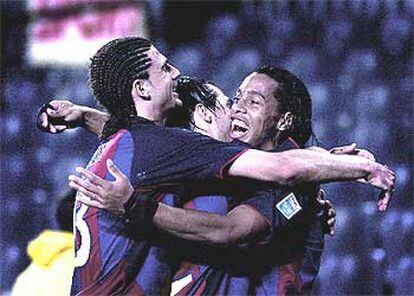 Motta y Luis García se abrazan a Ronaldinho tras uno de los goles del brasileño.
