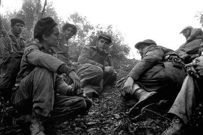 Ernesto Che Guevara, fumando una pipa, y Fidel Castro,   a su izquierda, en Sierra Maestra, en septiembre de 1957.