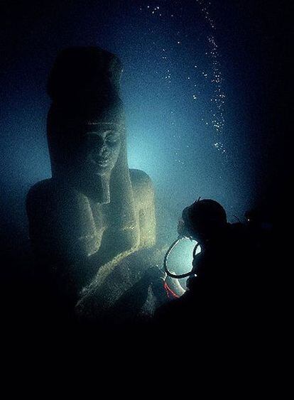 Un submarinista con una colosal estatua de granito rojo que representa al díos Hapi y que decoraba el templo de Heraclion.