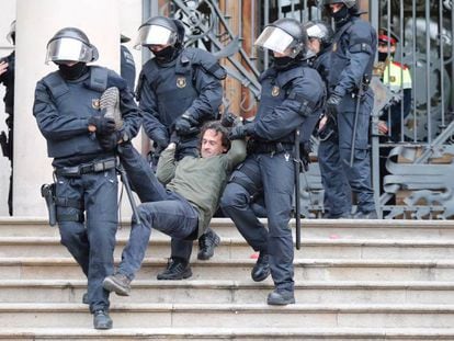 Agentes antidisturbios desalojan a uno de los manifestantes.