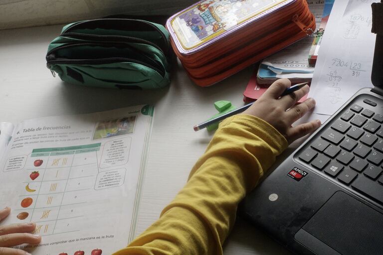 Un niño estudiando en su casa.