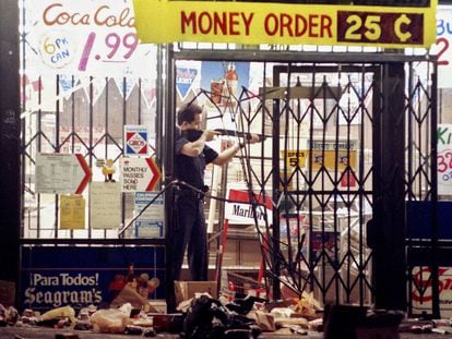 Un policía encañona a un ladrón en una tienda de alimentación de Los Ángeles, el 30 de abril de 1992, la segunda noche de disturbios.