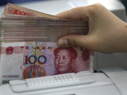 Una empleada cuenta yuanes en una sucursal bancaria en Huaibei