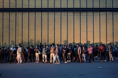 Un grupo de personas esperan un autobús para regresar a casa antes de un nuevo toque de queda de 20:00 a 4:00 en el centro de Nairobi, Kenia, el 27 de marzo de 2021.