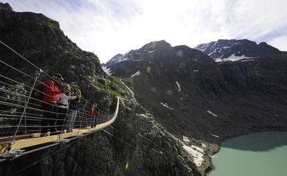 Turistas en el puente de Triftbrucke, en los Alpes suizos.