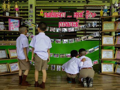 Compañeros de uno de los niños atrapados en la cueva de Tham Luang (Tailandia) le rinden tributo a la entrada de su escuela este lunes.