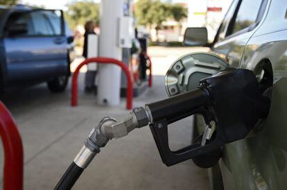 Un cotxe posa gasolina en una gasolinera.