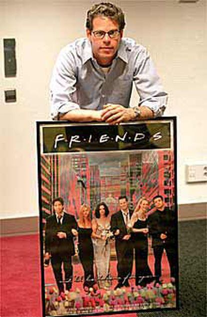 Andrew Reich, junto a un cartel de la serie Friends.