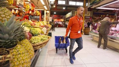 Un empleado recoge pedidos de Amazon en el mercado de La Paz en Madrid.