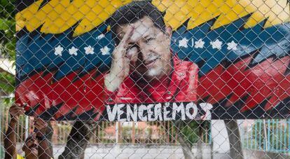 Un hombre cuelga un cartel aleg&oacute;rico al presidente de Venezuela, Hugo Ch&aacute;vez, en Caracas (Venezuela). 