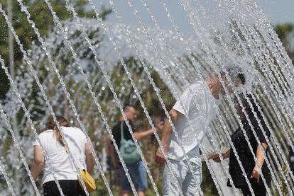Un hombre se refrescaba el sábado en una fuente para luchar contra las altas temperaturas, en Valencia. 
