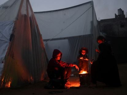 Refugiados palestinos se calientan al fuego en Rafah, al sur de la Franja de Gaza.
