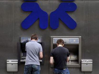 Dos clientes utilizan los cajeros del Royal Bank of Scotland en Londres.