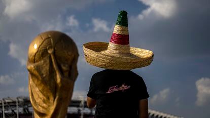 Un seguidor de la selección mexicana, junto a una réplica del trofeo de la Copa del Mundo, en Doha (Qatar).