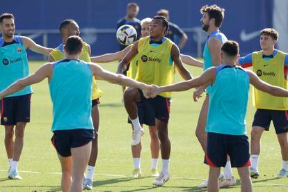El defensa francés del Barcelona, Jules Koundé, en el centro junto a Gerard Piqué, en el entrenamiento del equipo este sábado.