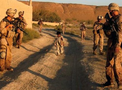 Un niño camina entre un grupo de "marines" del 2º Batallón del 8º Regimiento que patrullan con soldados afganos en la provincia de Helmand