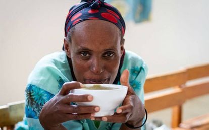 Una mujer come un tazón de puré en un centro de alimentación terapéutica de Zway, en Etiopía.