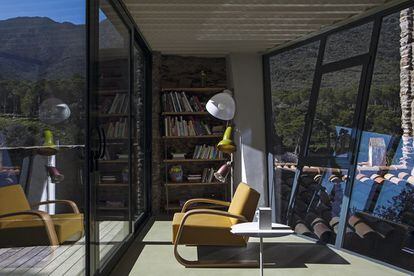 Vista al patio más pequeño que baña de luz y vistas la casa. La butaca es un diseño de Alvar Aalto que produce Artek. La estantería es el modelo Tría de Massana y Tremoleda que fabrica Mobles 114. La mesilla de apoyo es de Cassina.