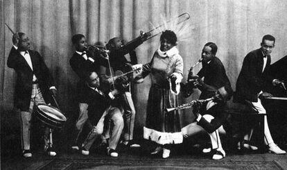 Junto con Bessie Smith (no eran familiares a pesar de compartir apellido), Mamie Smith (Cincinnati, 1883-Nueva York, 1946)  es la gran dama de los primeros años del blues. De hecho, a Smith se le atribuye el primer gran éxito del blues. Se trata de una canción llamada ‘Crazy blues’ que se editó en 1920 y que se vendió por miles en discos de pizarra, uno de los primeros formatos sonoros. La repercusión de este tema abrió el mercado discográfico para el blues. Mamie protagonizó películas, tuvo una agitada vida amorosa seguida al detalle en las entonces llamadas “crónicas de sociedad” y acabó en una vorágine de drogas y alcohol que la condujo a la muerte con 63 años y entre penurias económicas. En la imagen, Mamie Smith y su grupo, los Jazz Hounds, en 1922.