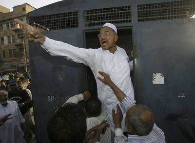 Un hombre grita consignas a favor de Sharif desde un furgón policial, tras ser detenido en una protesta en Karachi.