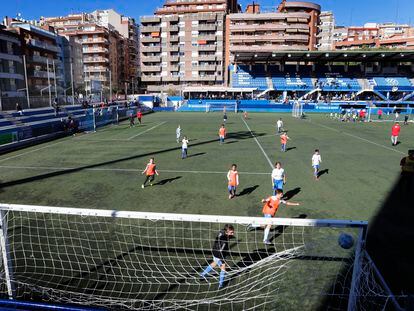 Niños de la escuela del Europa disputan un partido en el Nou Sardenya.