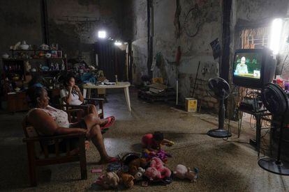 Una familia mira las noticias de la televisión local que muestran al primer secretario del Partido Comunista de Cuba y ex presidente Raúl Castro dirigiéndose a la audiencia de la sesión inaugural del VIII Congreso del Partido Comunista de Cuba.